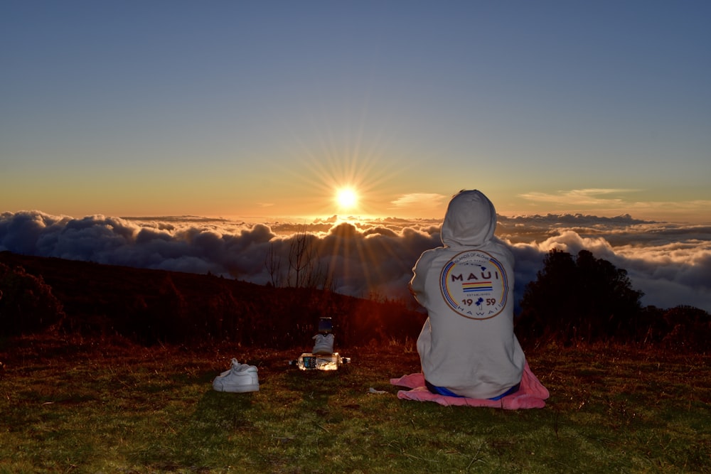 tenda branca e vermelha no campo de grama verde durante o pôr do sol