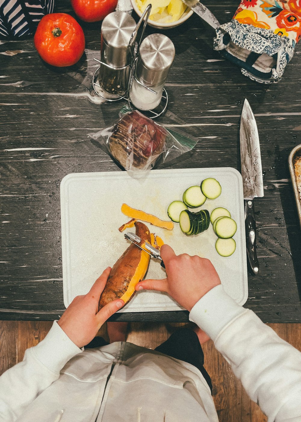 a person cutting vegetables on a cutting board