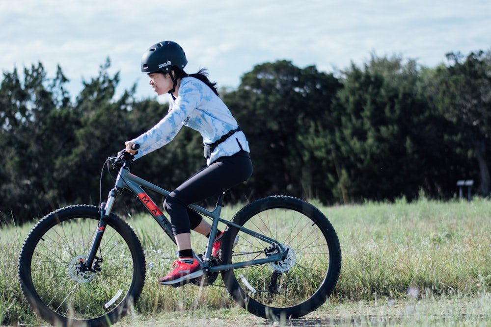 man in white long sleeve shirt riding red and black mountain bike