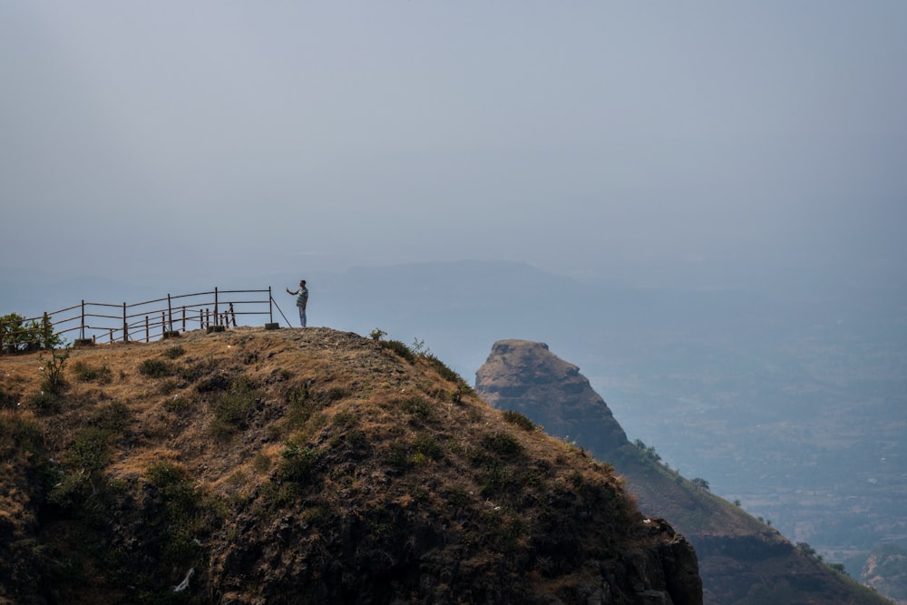 pessoa em pé no topo da montanha durante o dia