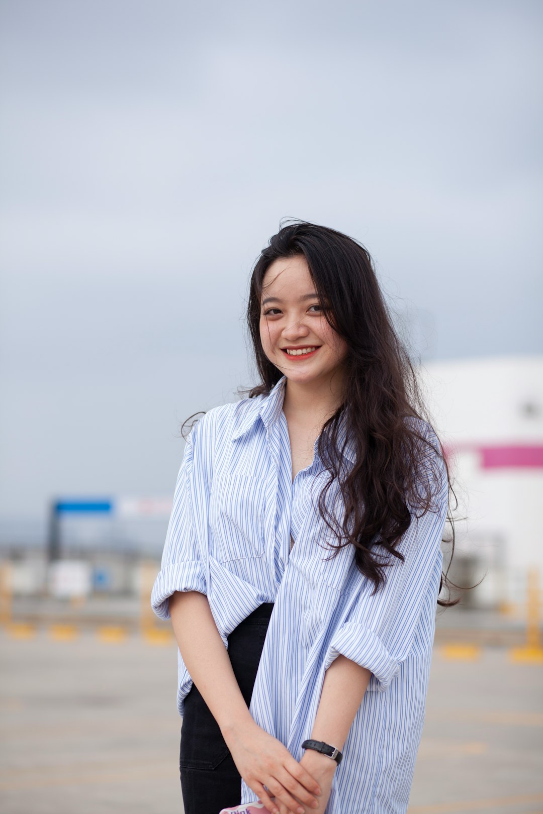 woman in white and blue stripe button up shirt smiling