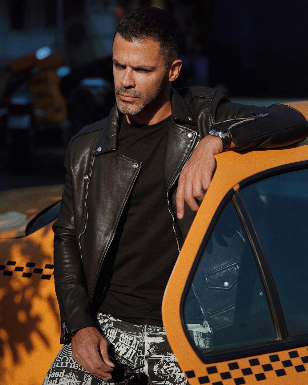 Foto zum Thema Mann in schwarzer Lederjacke sitzt auf gelbem Auto –  Kostenloses Bild zu Mannequin auf Unsplash