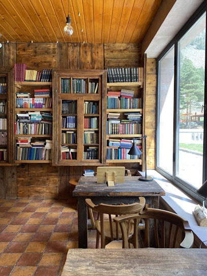 A warm interior of a traditional study hall with wooden benches and religious books.