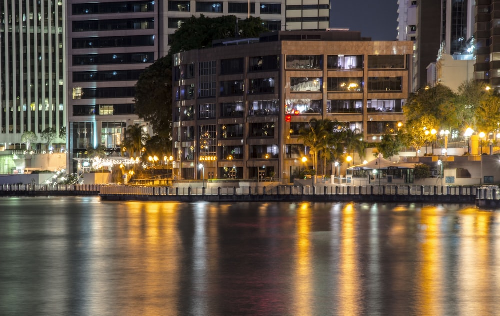 body of water near city buildings during night time