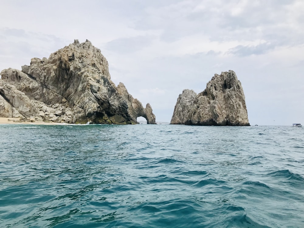 brown rock formation on body of water during daytime