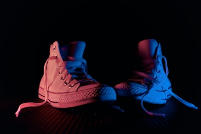Display of tactical boots and sneakers arranged on a dark surface with subtle blue lighting.