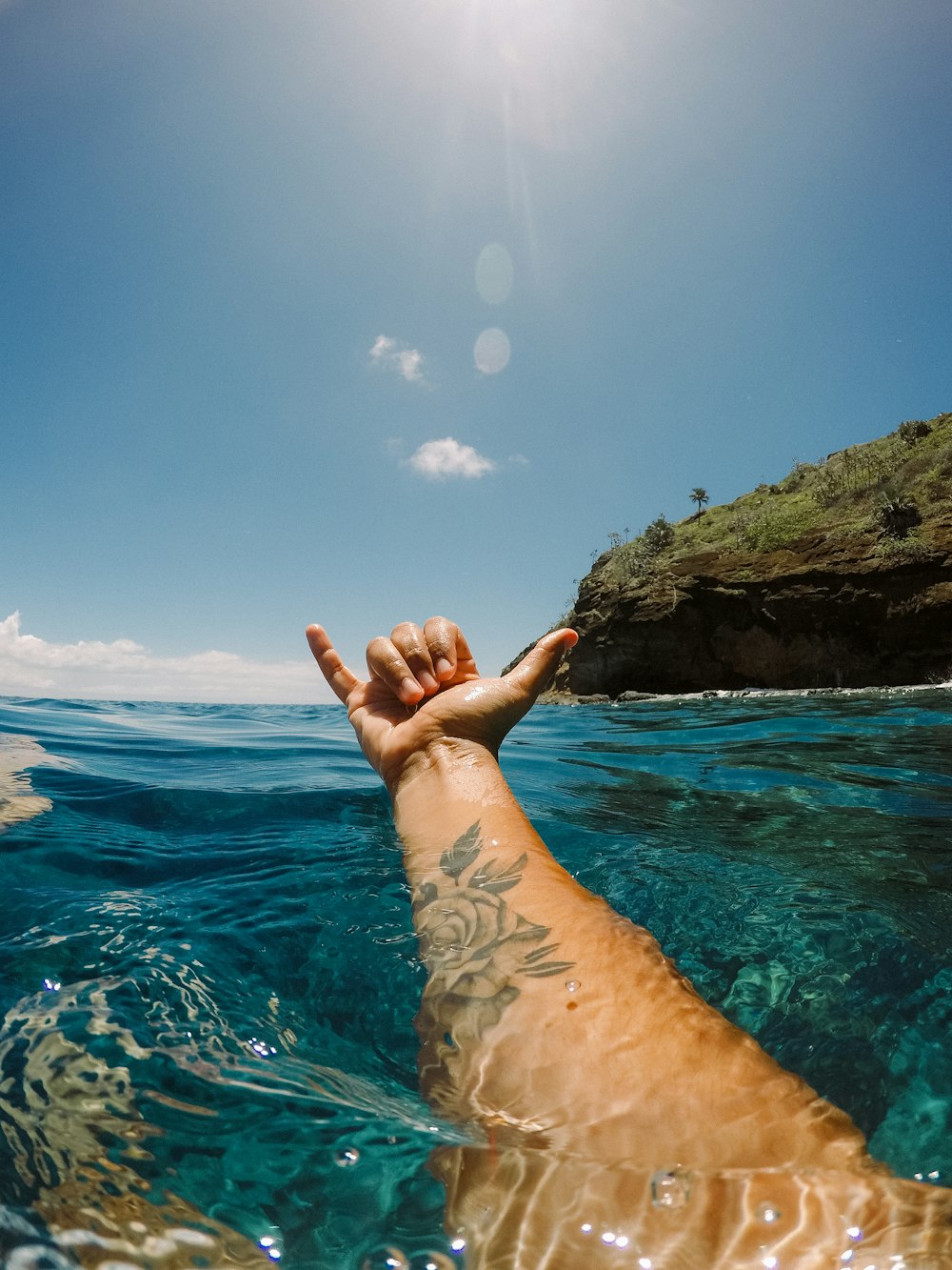 persons feet on body of water during daytime