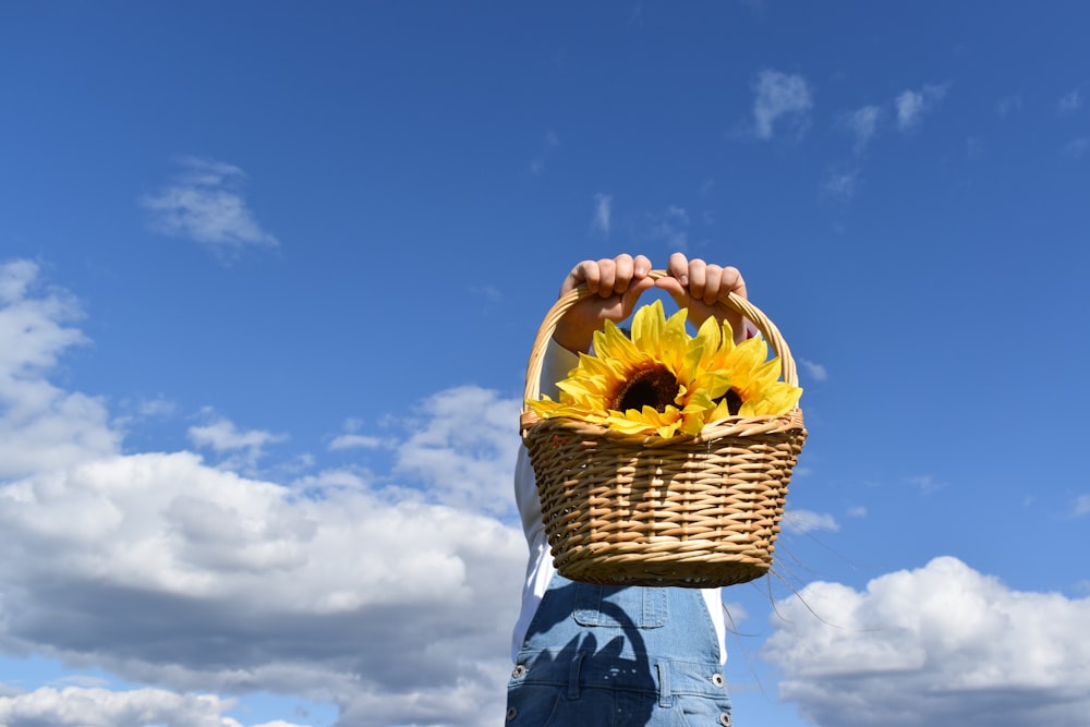 person holding sunflower bouquet during daytime