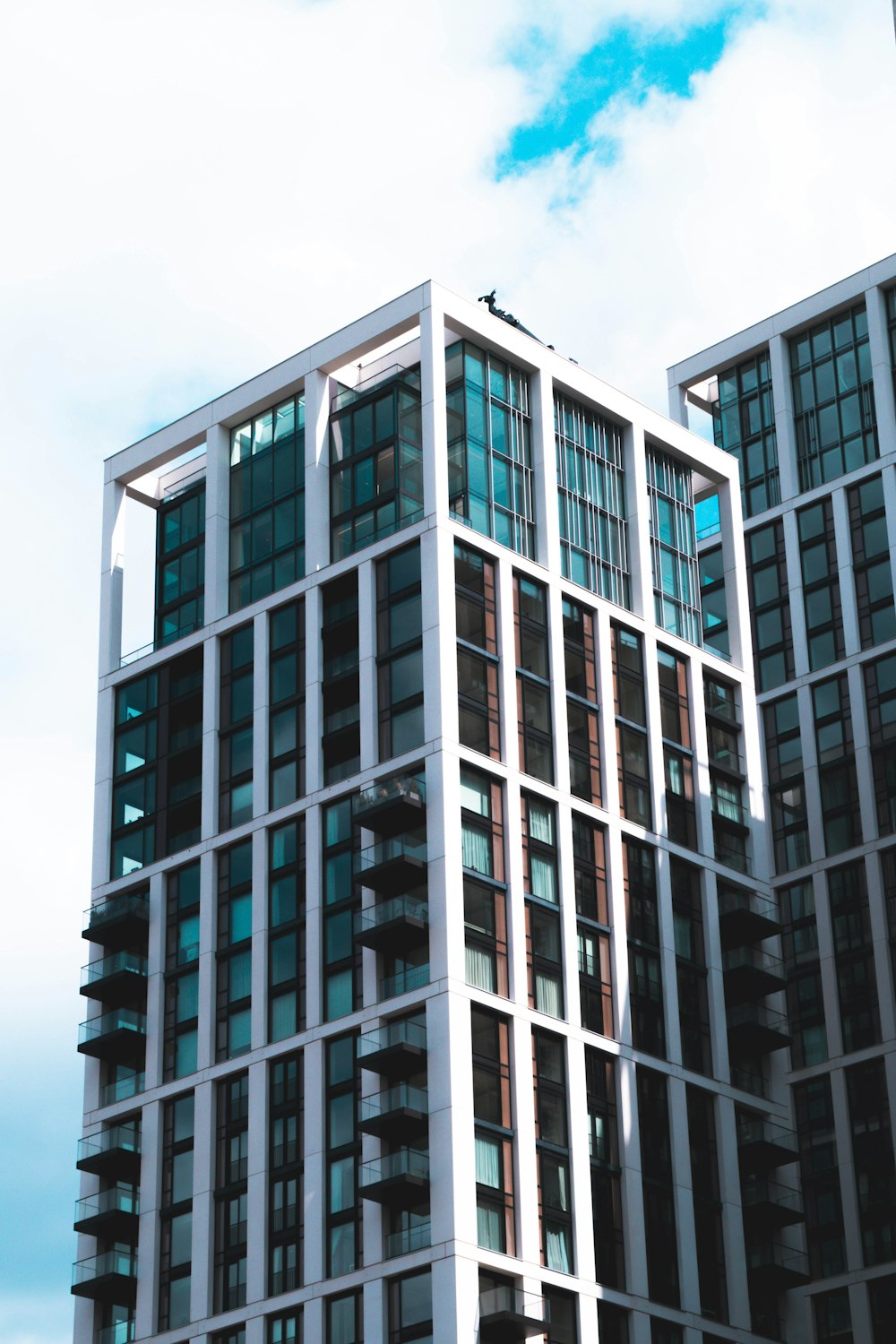 white and black concrete building under white clouds during daytime