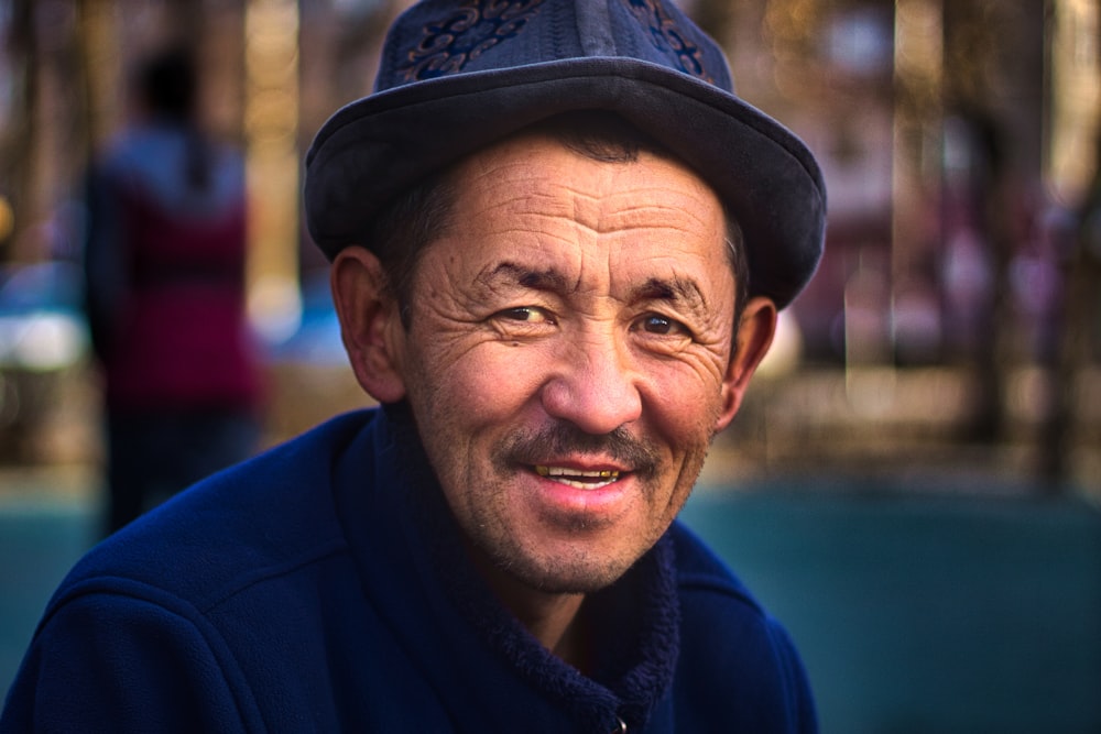 man in blue hoodie wearing black and brown cap