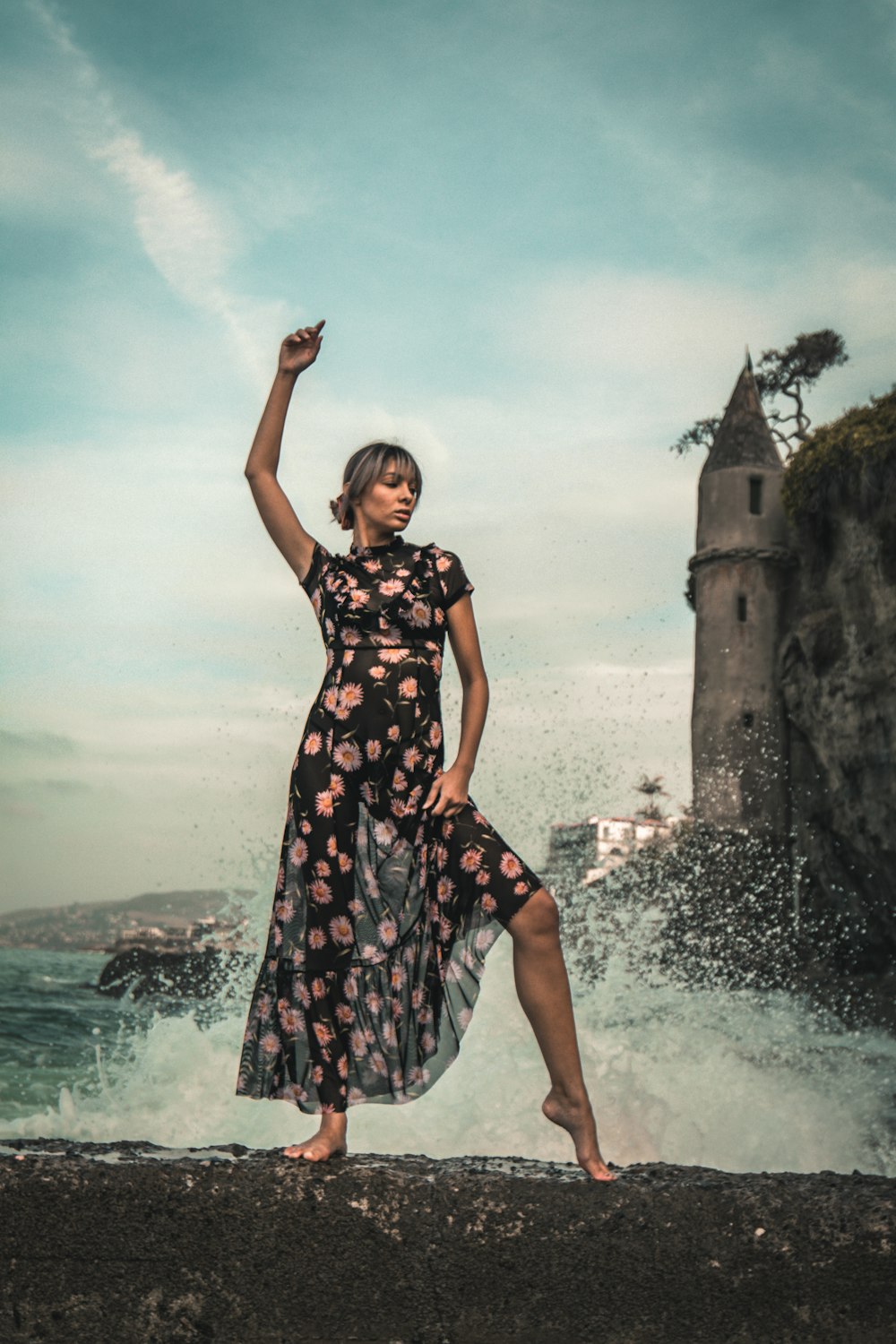 woman in black and red floral dress standing on gray concrete dock during daytime
