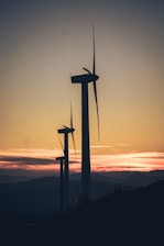 A wind turbine farm against a sunset backdrop.