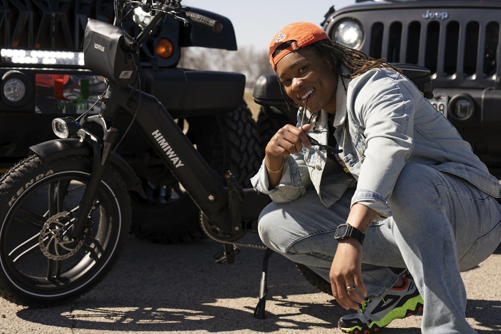 a woman kneeling down next to a motorcycle