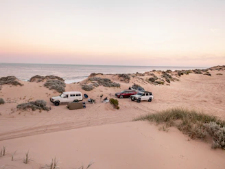 white suv on brown sand during daytime