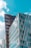 Geometric modern buildings with reflective glass facades under a bright blue sky, highlighting architectural design and urban development.