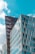 Geometric modern buildings with reflective glass facades under a bright blue sky, highlighting architectural design and urban development.