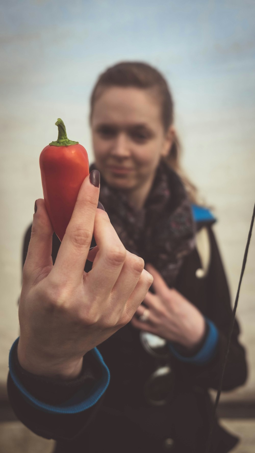 mulher que segura o pimentão vermelho