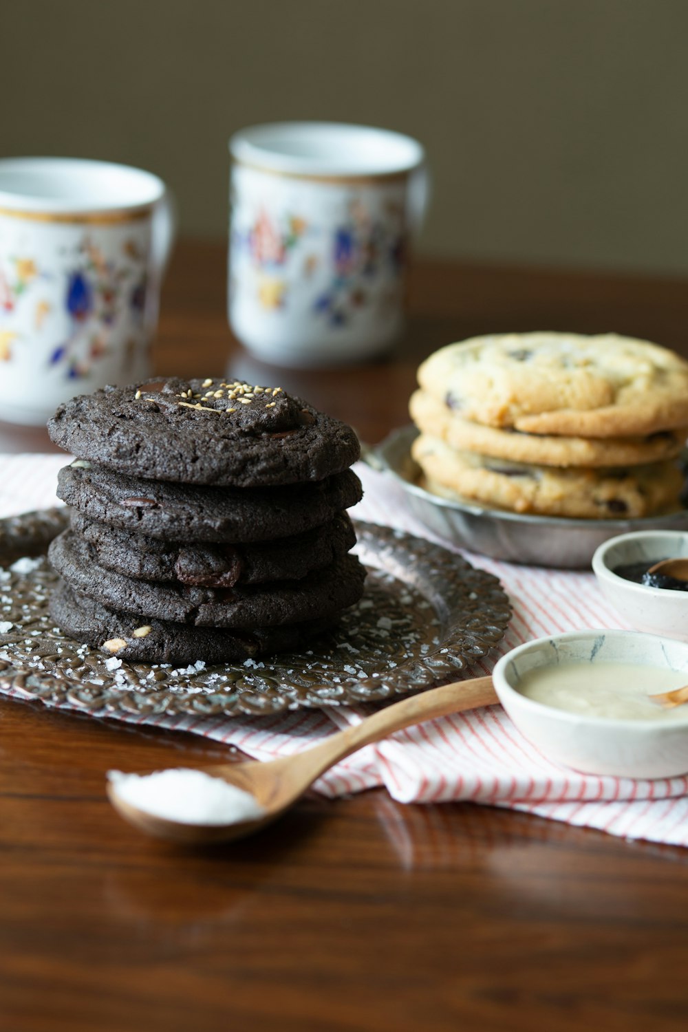 cookies on white ceramic plate beside white and blue floral ceramic mug on brown wooden table