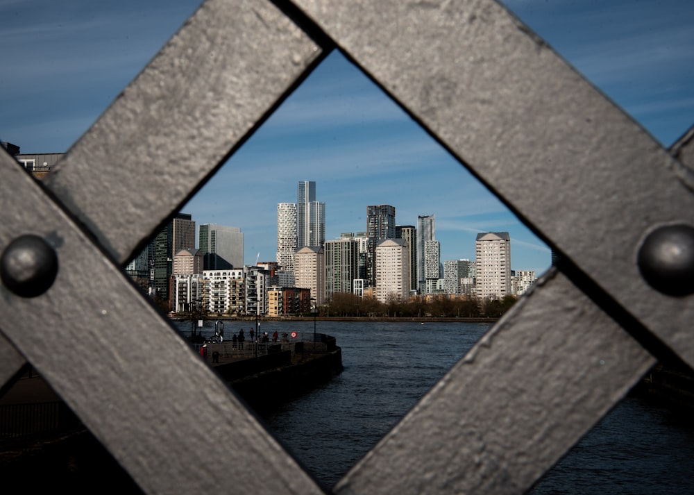 a view of a city through a metal fence