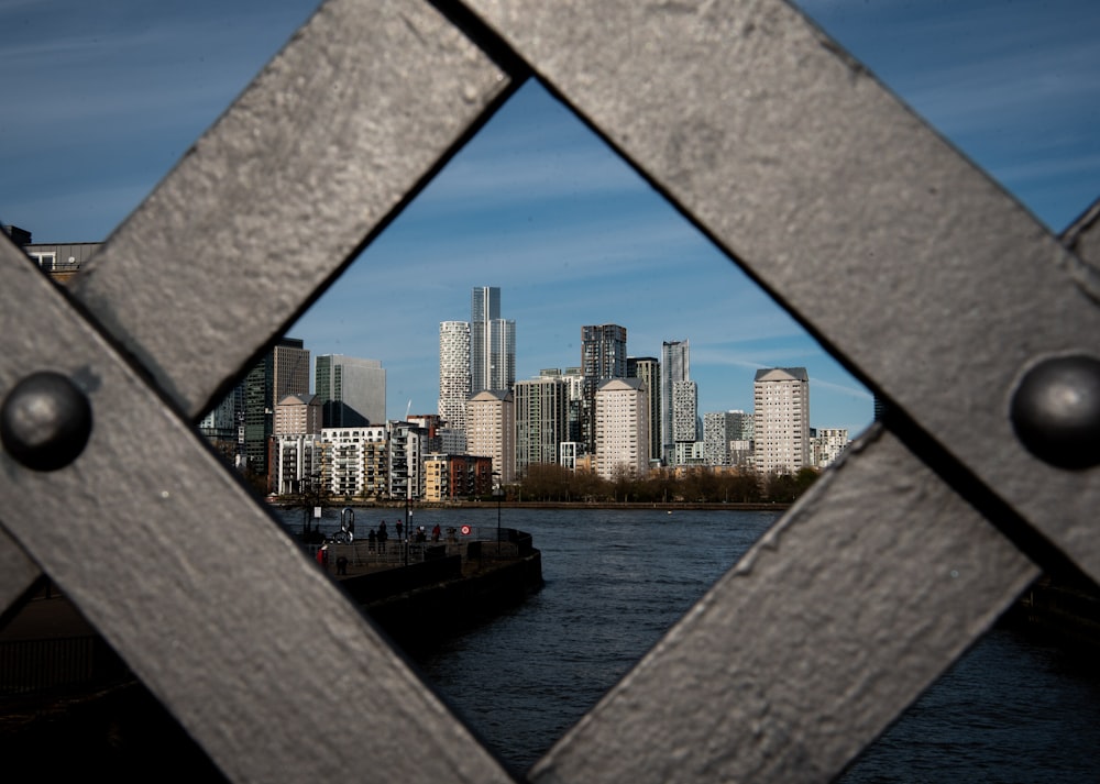 uma vista de uma cidade através de uma cerca de metal