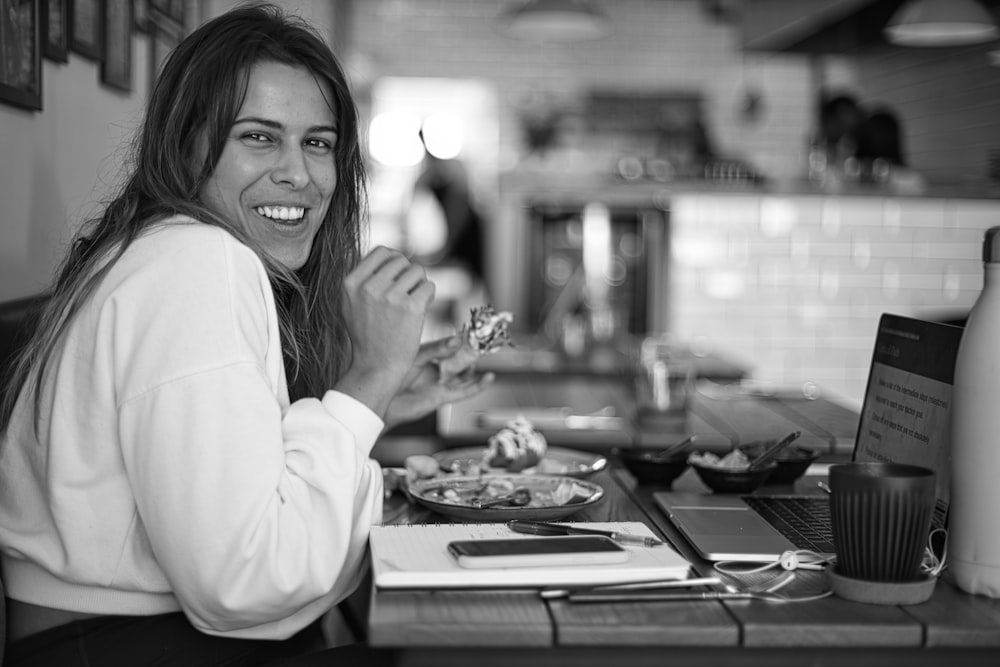 Mujer en camisa blanca de manga larga sonriendo