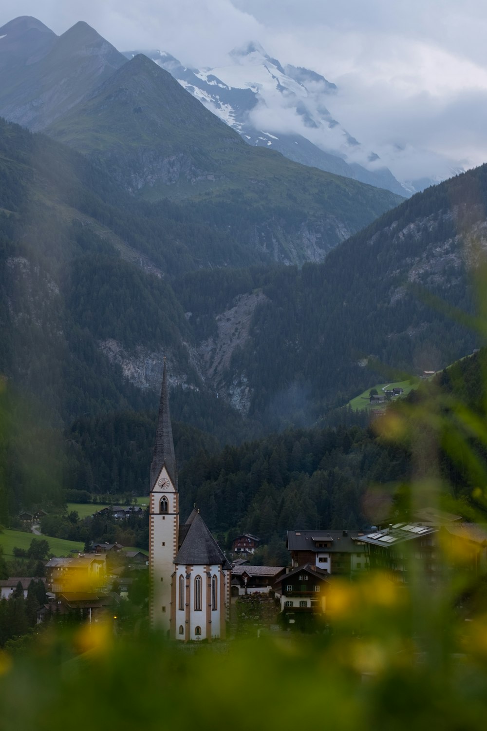 white and brown concrete building near green mountains during daytime