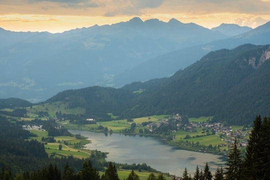 green mountains and green trees during daytime in Weissensee Austria