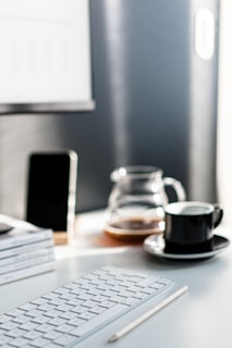 A modern workspace with a laptop, smartphone, and notebook on a clean desk.