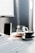A modern workspace featuring a sleek gadget and stylish accessories on a clean desk.