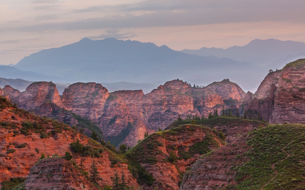 brown and green mountains under white clouds and blue sky during daytime