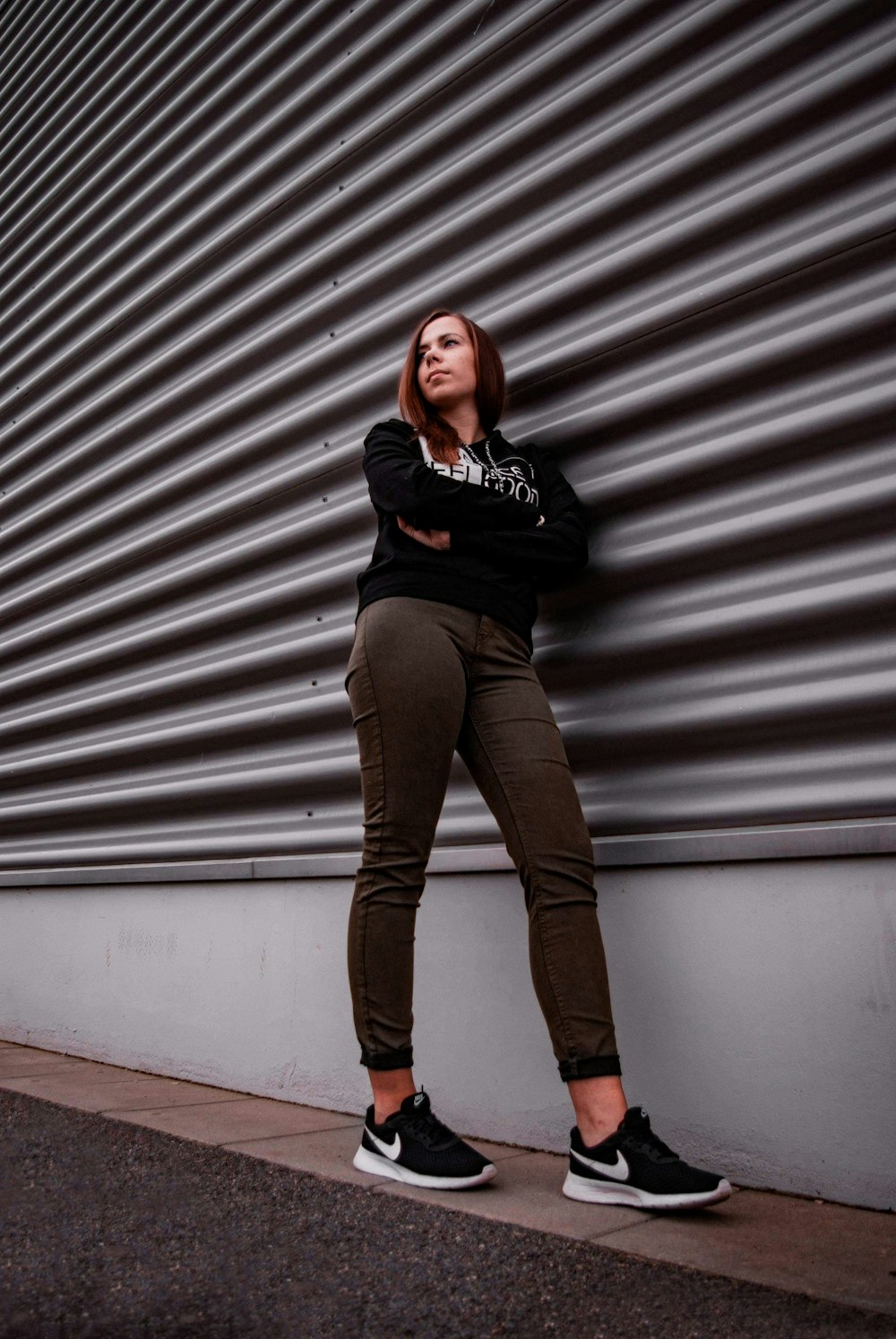 woman in black and white striped long sleeve shirt and brown pants standing beside gray roll