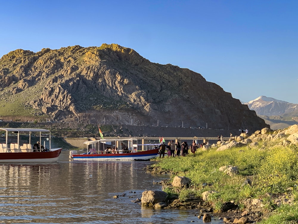 people riding red boat on river during daytime