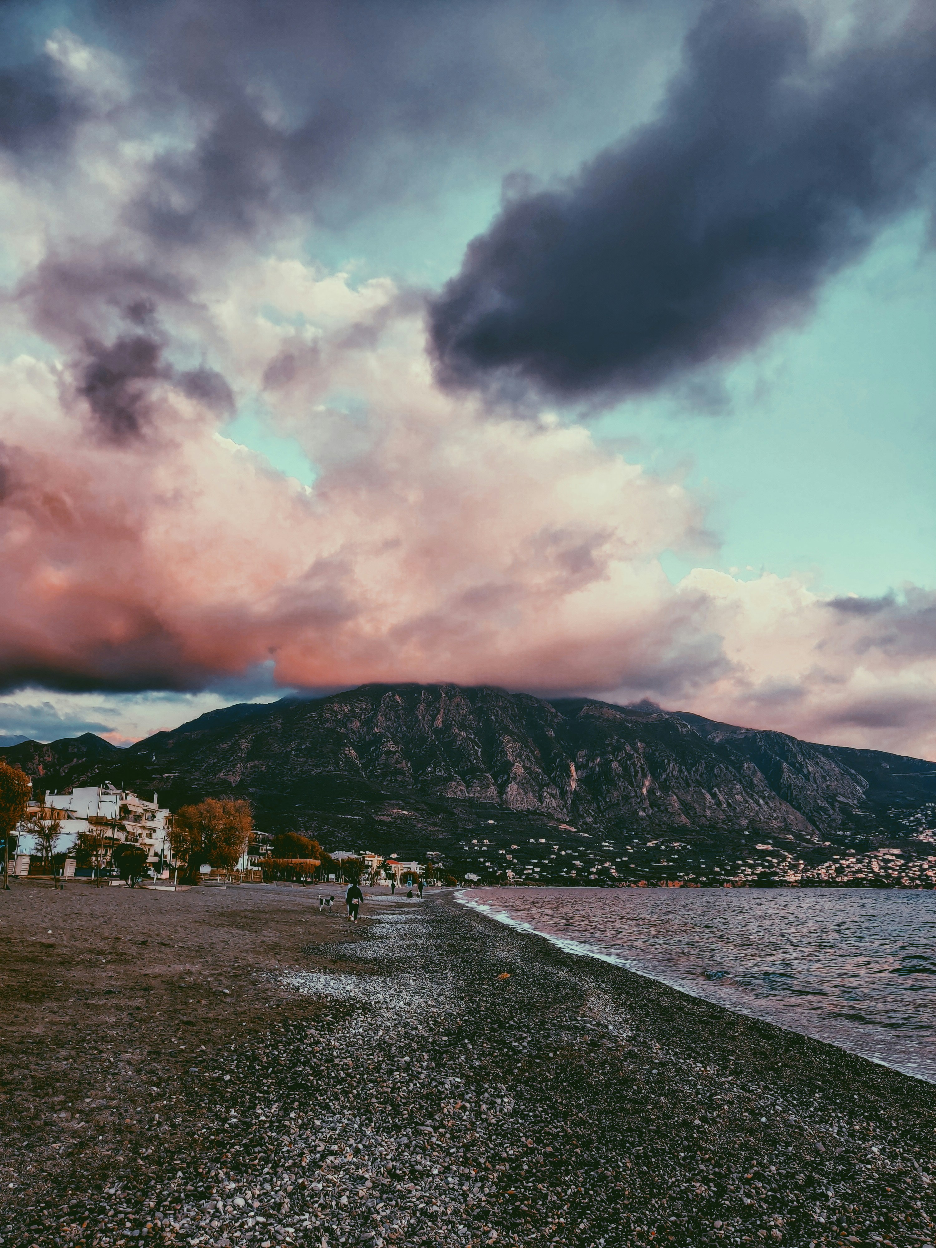 white and brown houses near mountain under white clouds during daytime