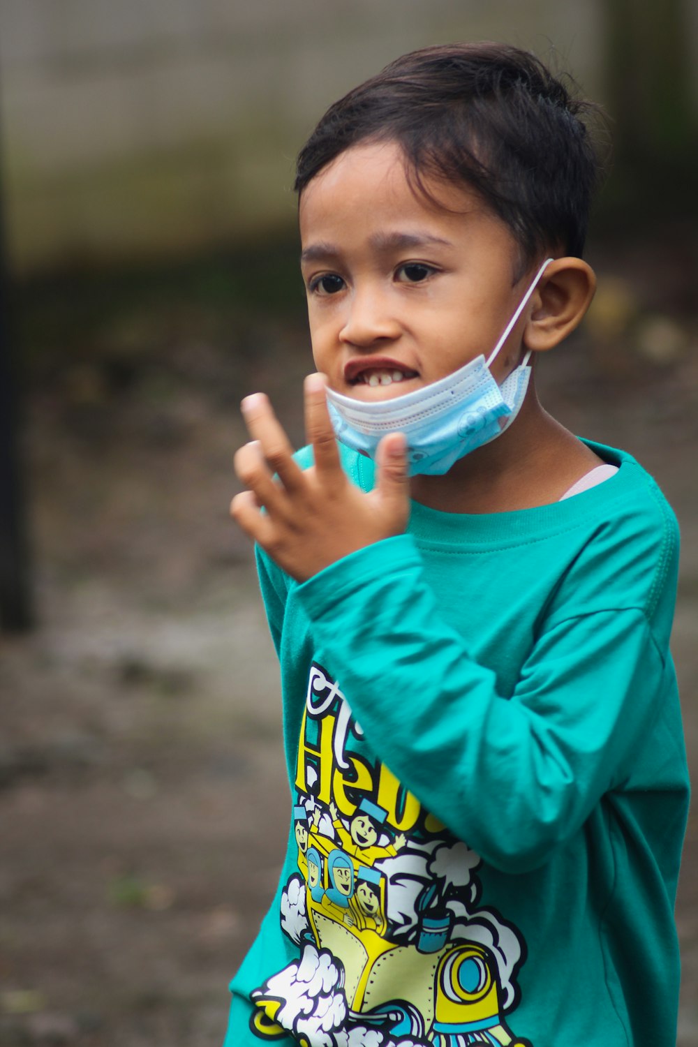 boy in blue crew neck t-shirt holding white and blue plastic container