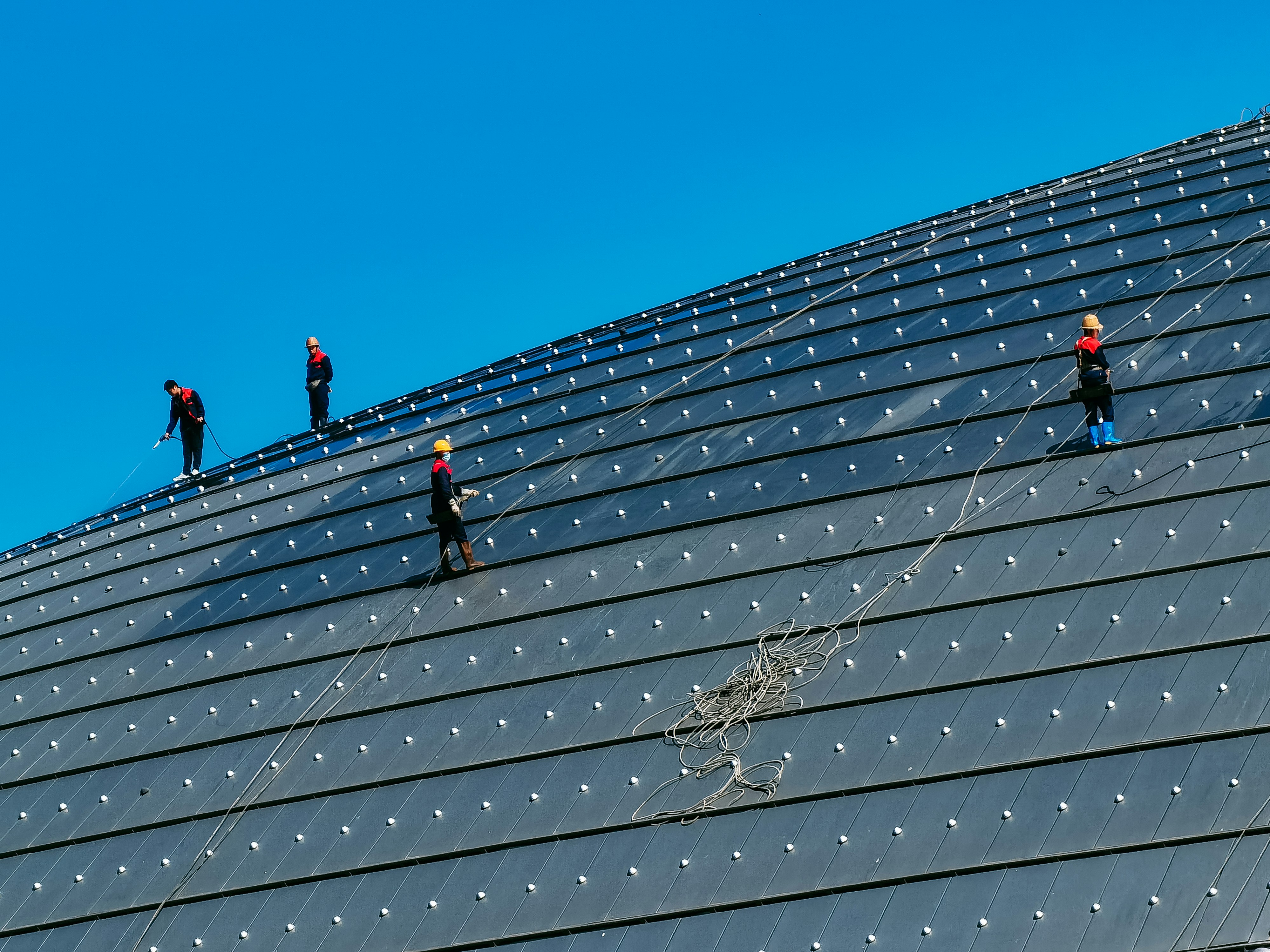people climbing on brown wooden roof under blue sky during daytime