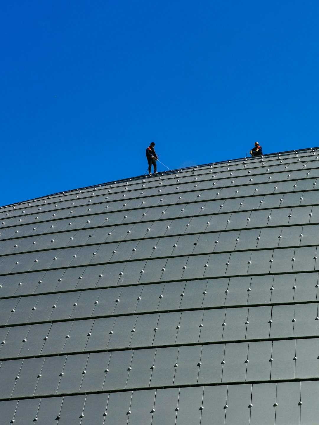 3 men on top of building under blue sky during daytime