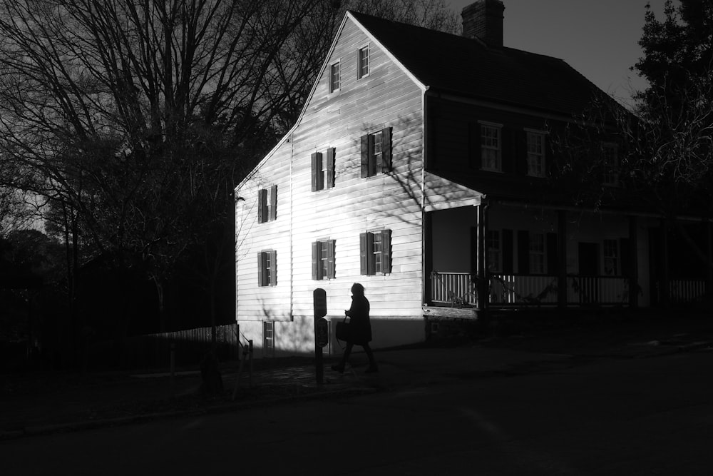 2 personnes debout devant la maison blanche et brune