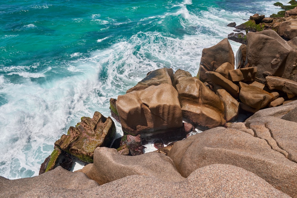 roches brunes sur le bord de la mer pendant la journée