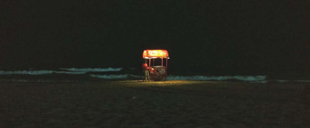 Camion orange et noir sur sable brun pendant la nuit