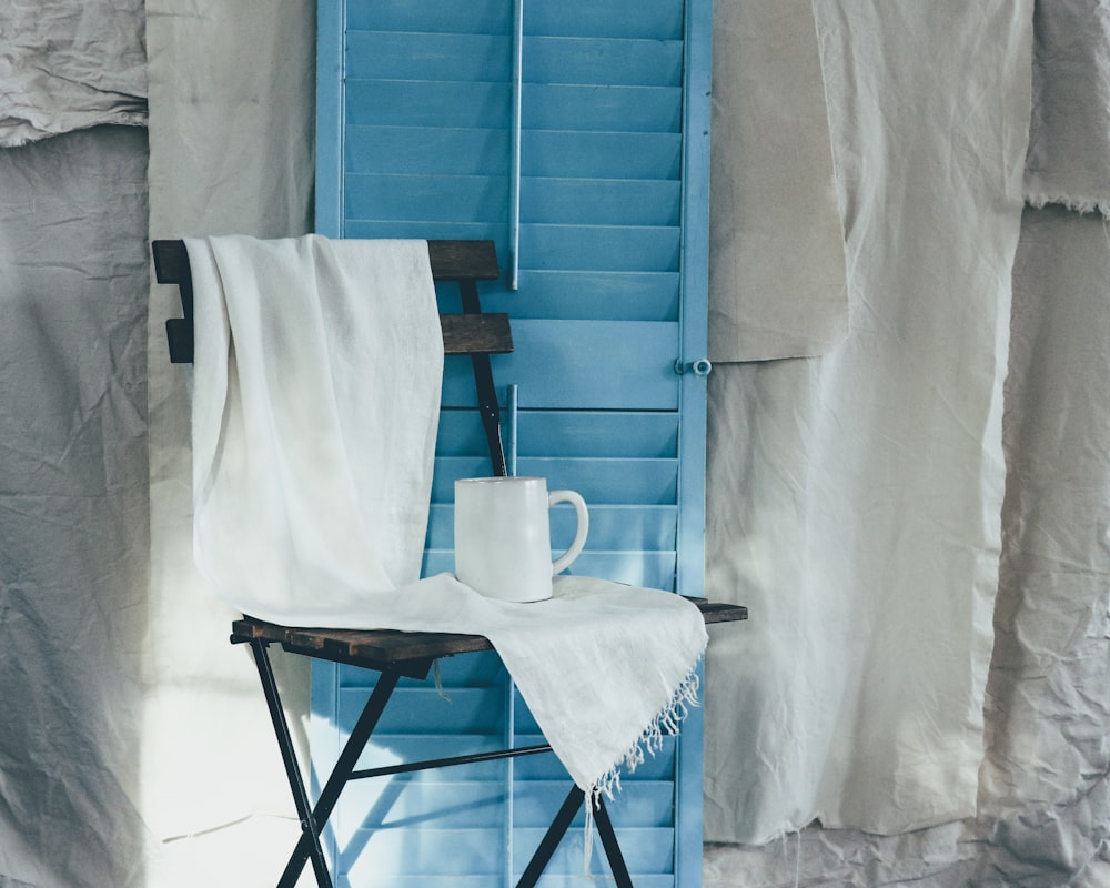 white ceramic mug on white table cloth