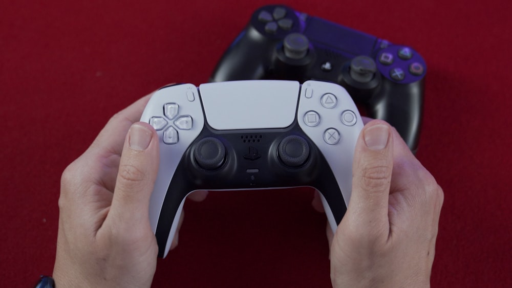 Persona che tiene il controller di gioco nero