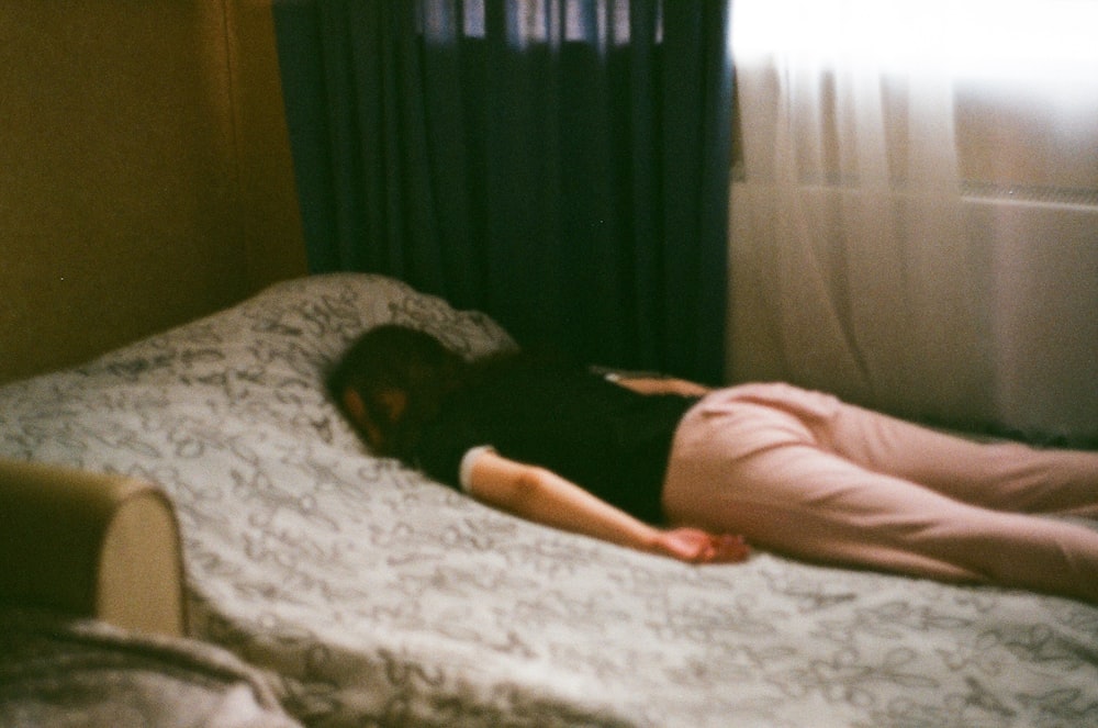mulher na camisa rosa deitada na cama