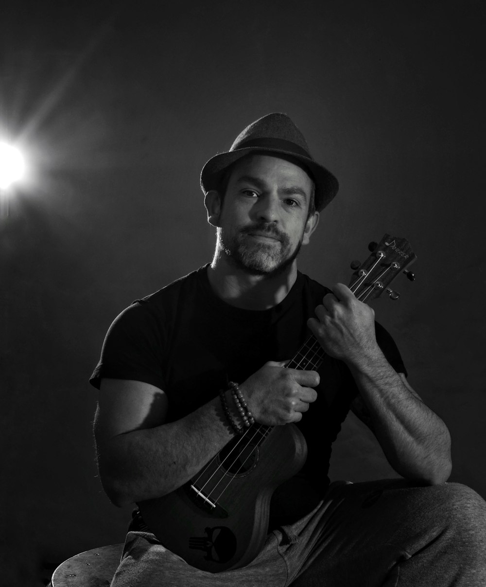 man in black crew neck t-shirt playing acoustic guitar