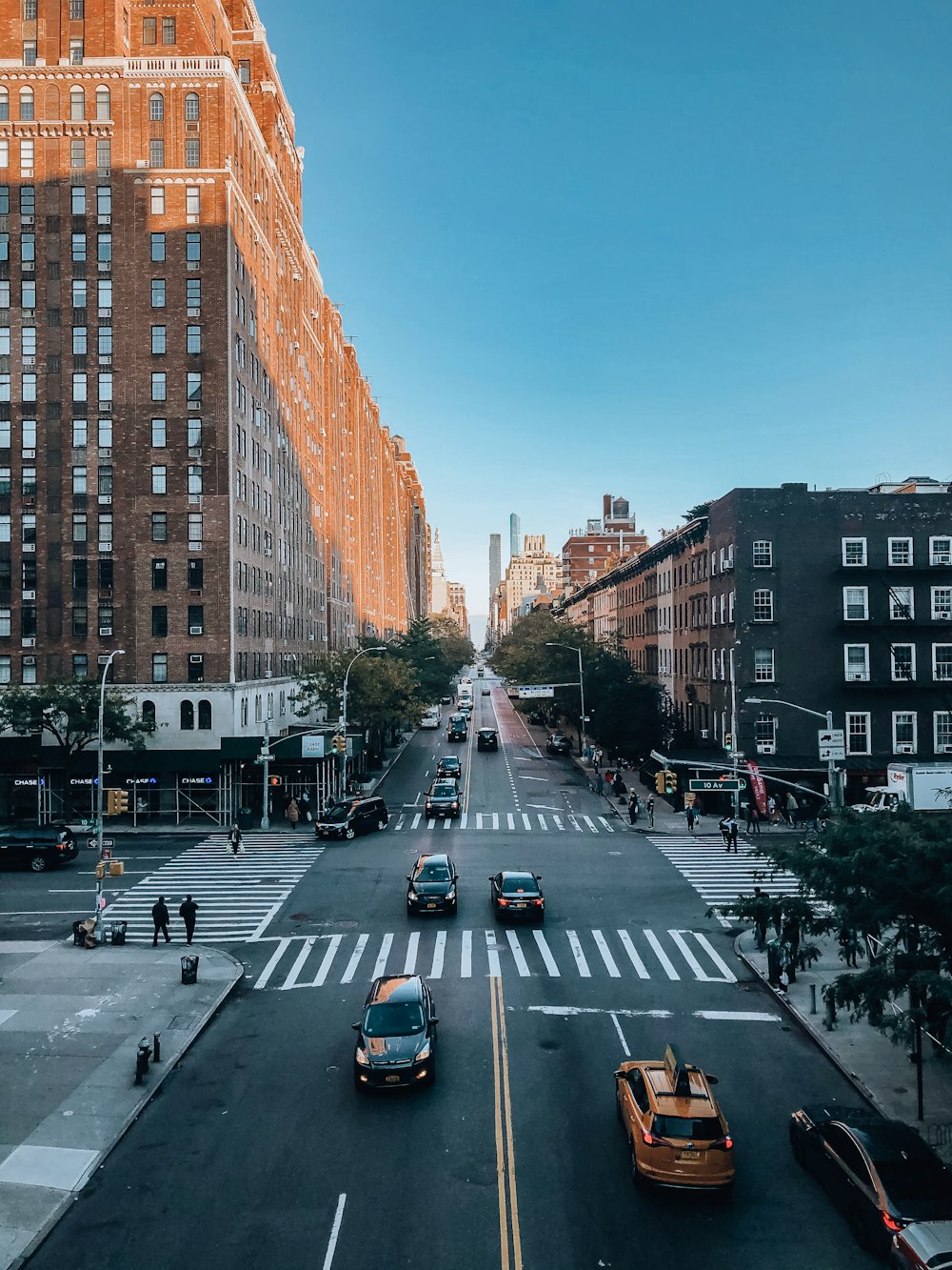 cars on road between high rise buildings during daytime