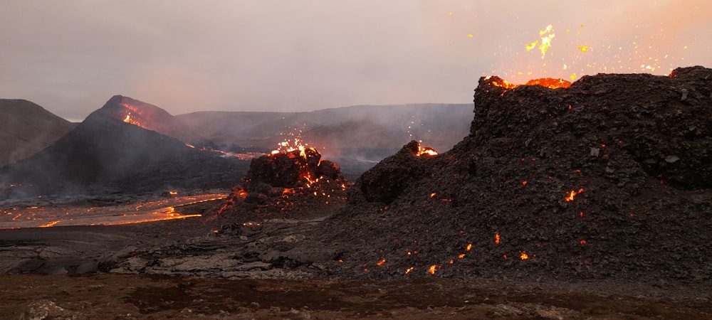 fire on black rock formation during daytime