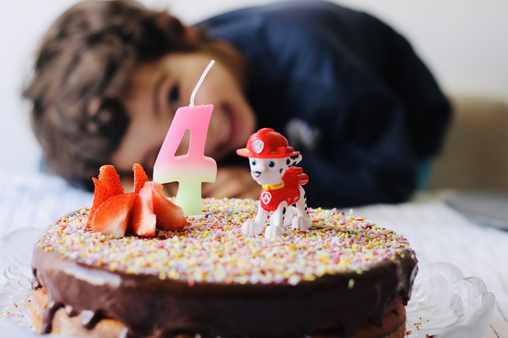 red and white plastic toy on brown cake