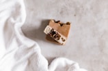 Close-up of a triangular herbal soap bar resting on natural linen fabric.