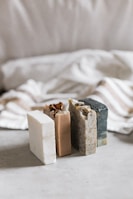 A set of handmade soaps arranged artfully with natural ingredients around them.