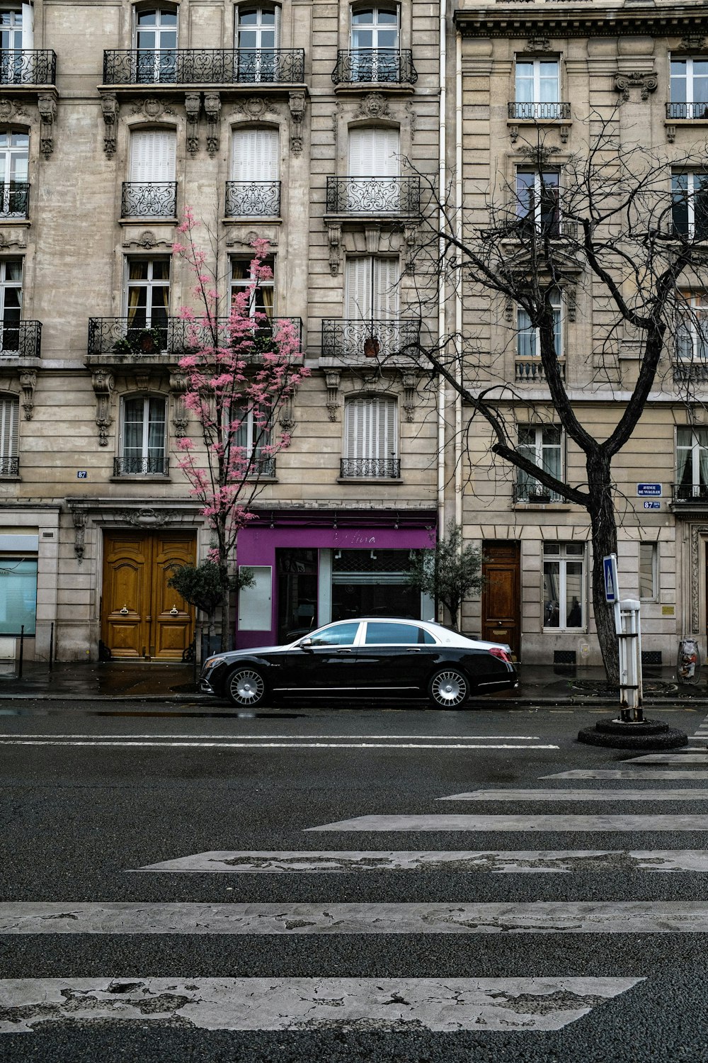 silver sedan parked beside brown concrete building during daytime