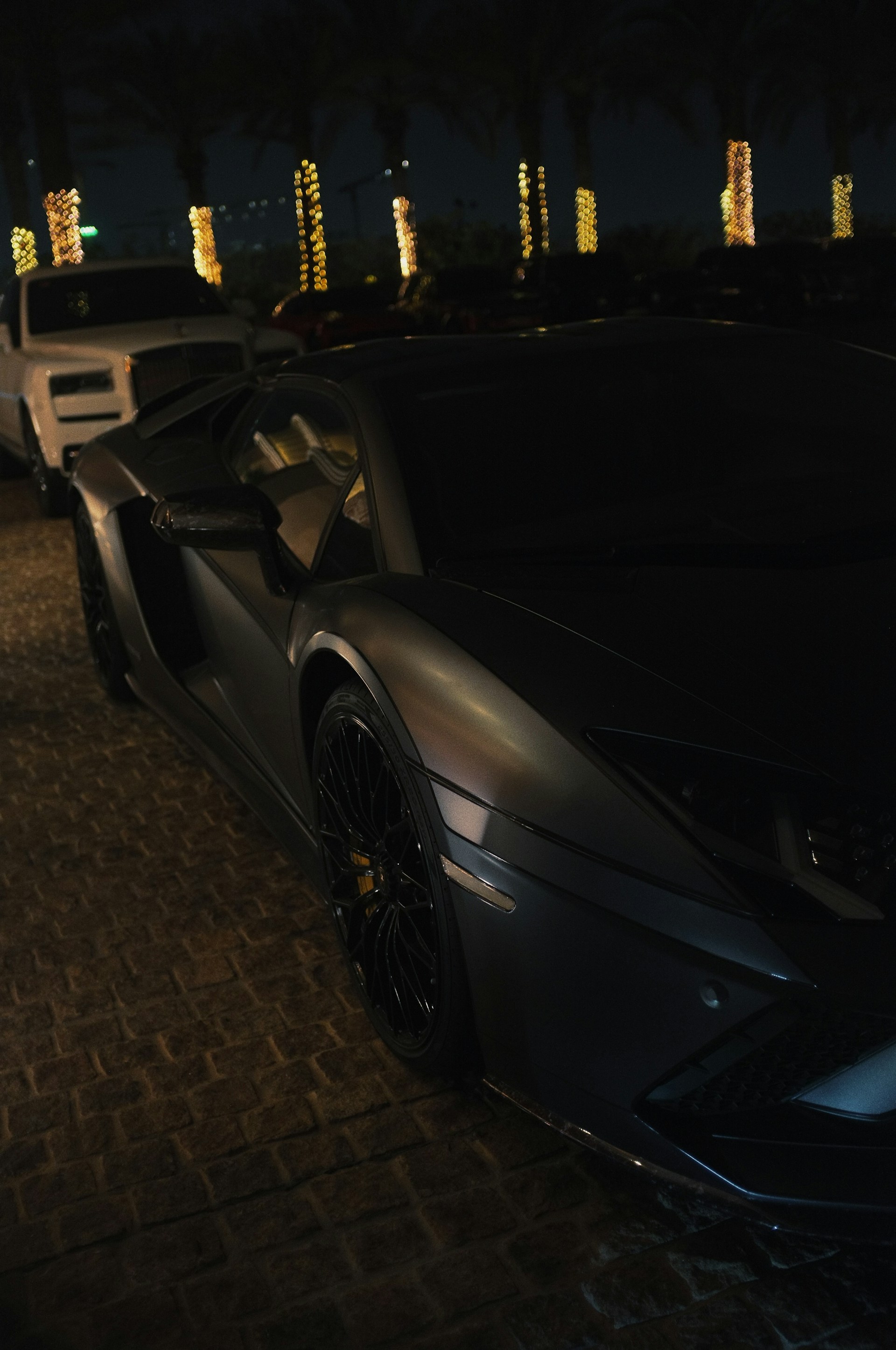 A sleek black luxury SUV parked by a palm-lined Miami street at sunset, ready for a chauffeured ride.